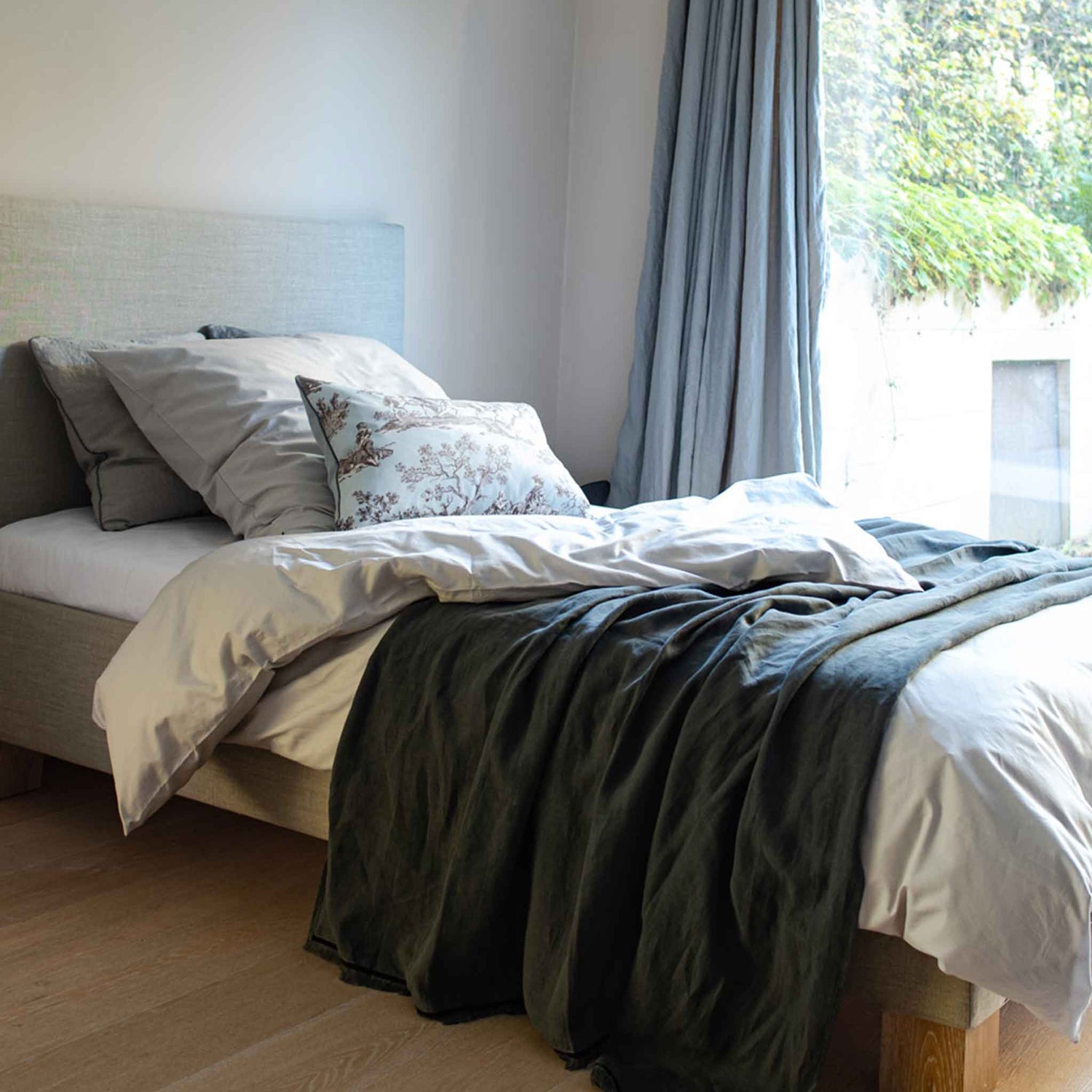 Bett mit dekorativen Kissen und anthrazit Tagesdecke aus Leinen