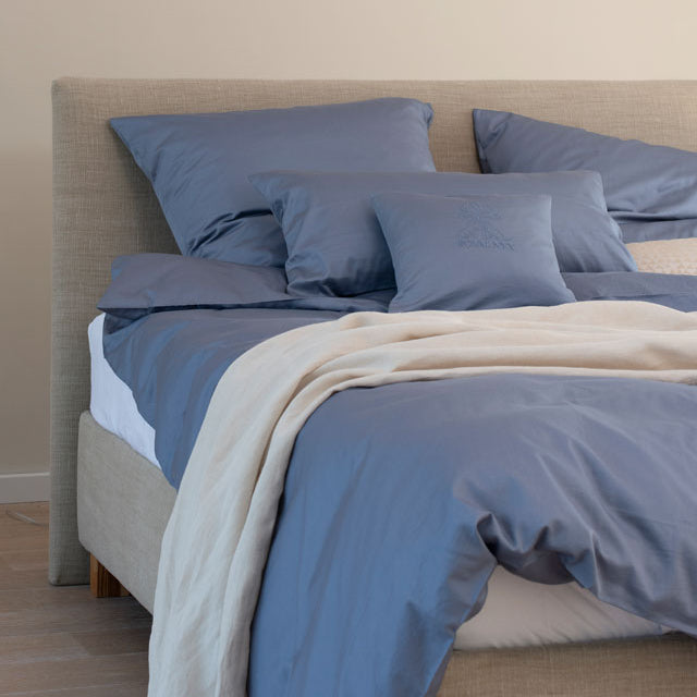 naturl bed room with ocean blue basic bed linen and naturel linen blanket